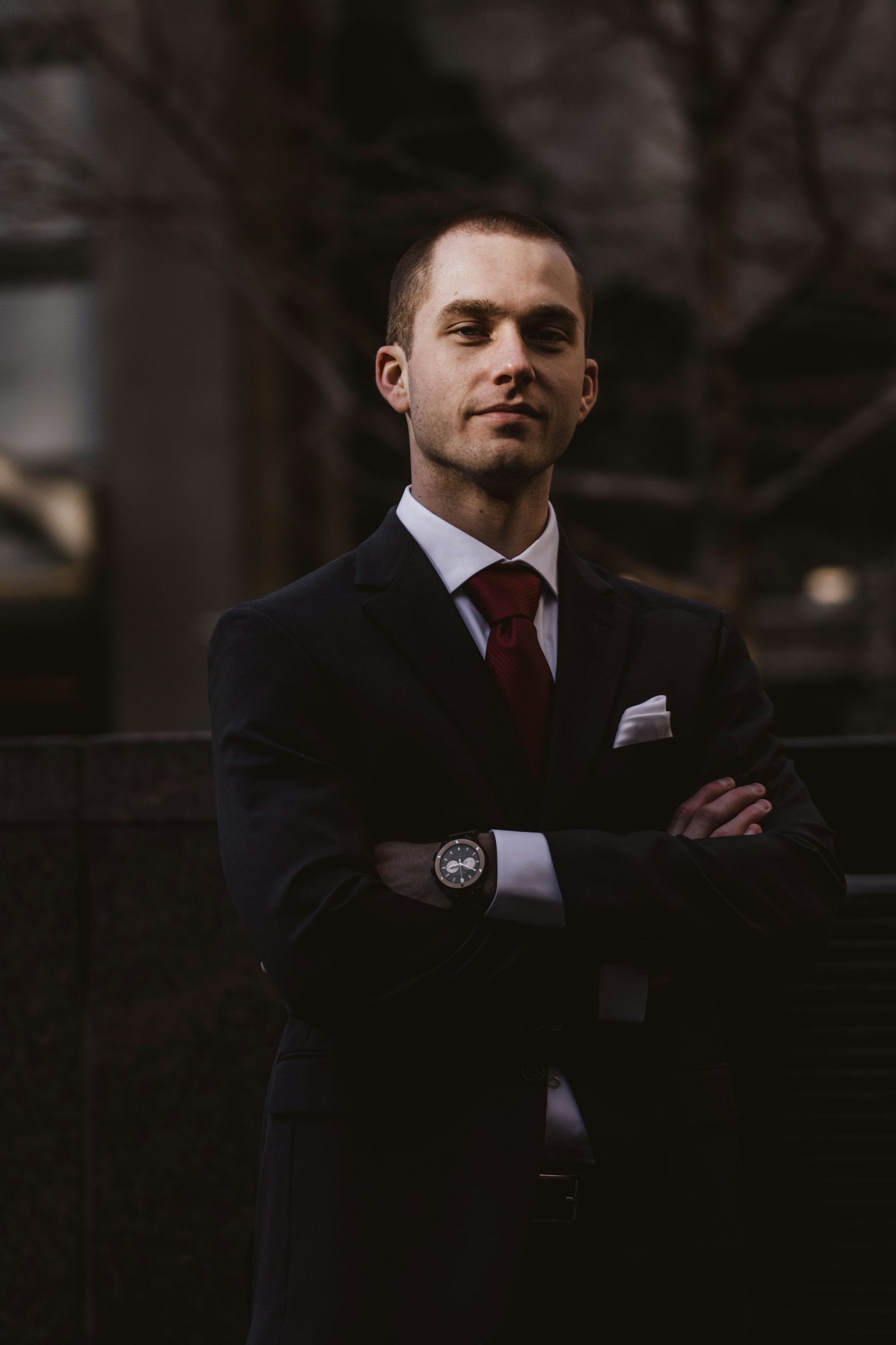 An executive in a suit, arms crossed, ready to lead
