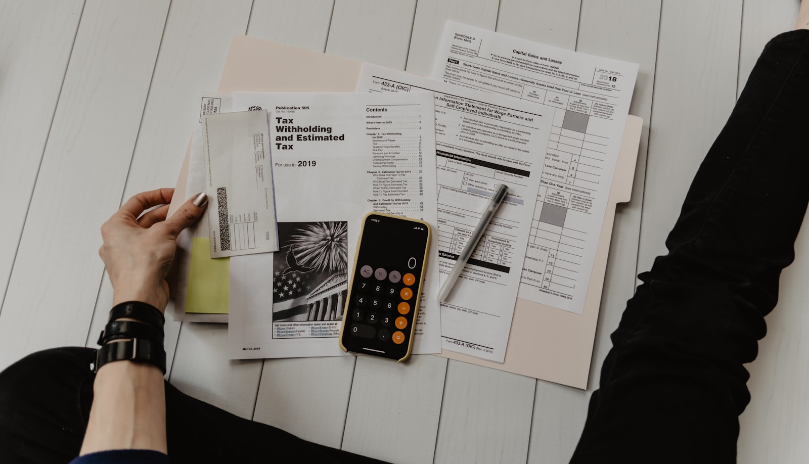 Tax forms and a calculator arranged on a desk